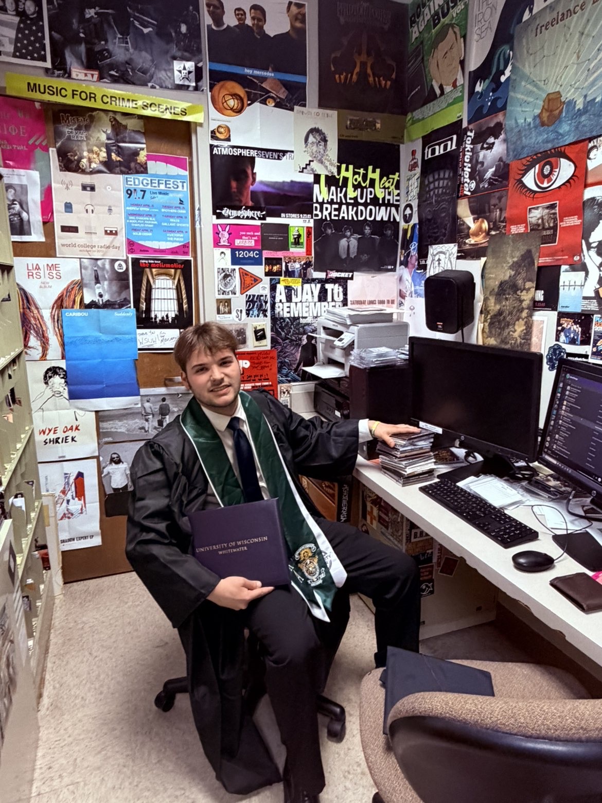 Ryan Hoke in graduation attire inside the radio station